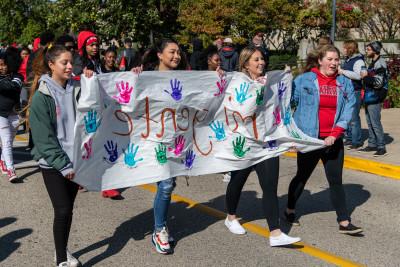 Students in the organization Mi Gente walk in the 首页coming Parade.